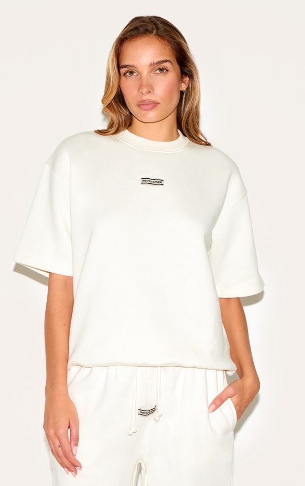 PRETTYLITTLETHING Cream Badge Detail Oversized Short Sleeve Sweatshirt